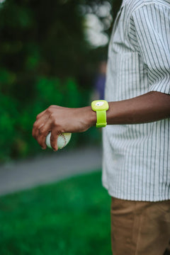 Child wearing the green Littlebird band while holding a baseball