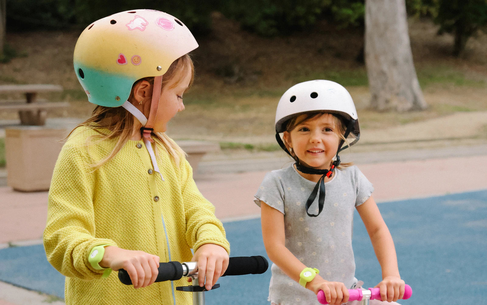 Girls wearing Littlebird tracker riding scooters